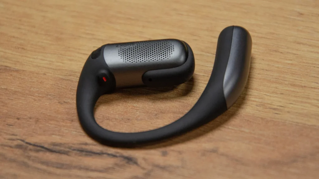 Nahaufnahme des Shokz OpenFit Pro Ohrbügels aus flexibler Titan-Legierung und weichem Silikon, der im Ergonomie-Test 2026 einen sicheren Halt gegen die Schwerkraft demonstriert.